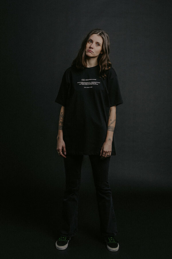 model in black focus t-shirt on a black background