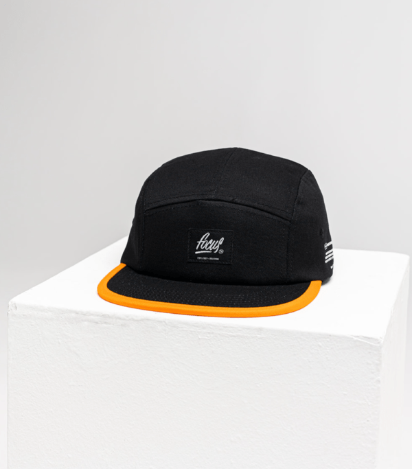 black 5 panel cap with orange lip and woven focus label on the front panel