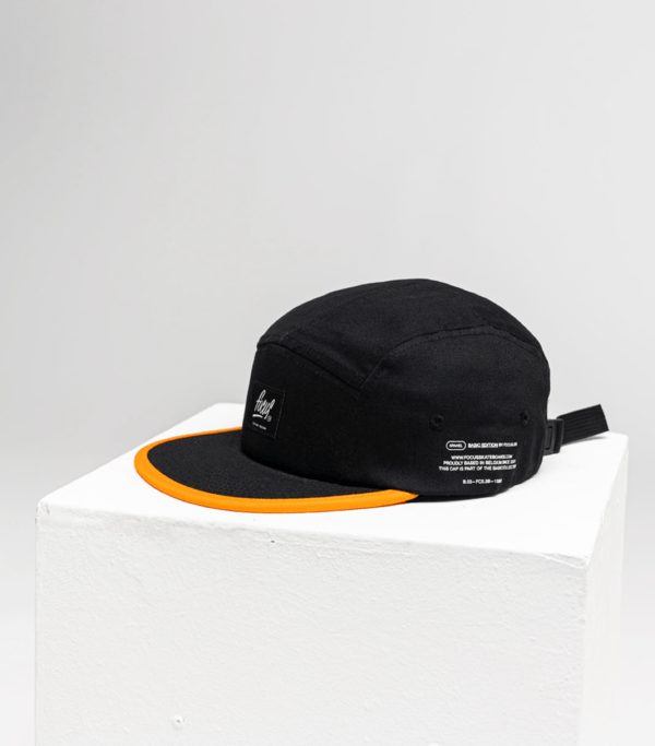 black 5 panel cap with orange lip and writing on the left side