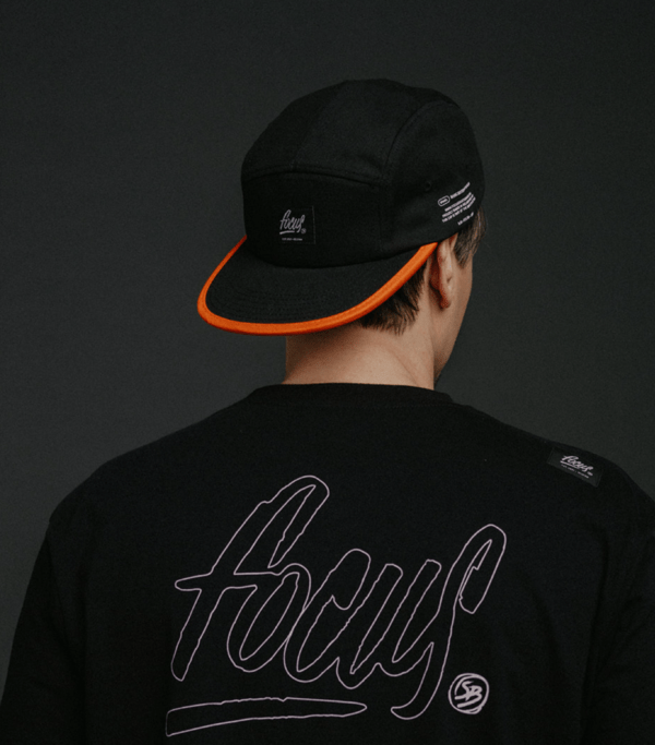 back of black 5 panel cap and black t-shirt on black background