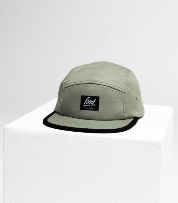 green 5 panel cap on white cube