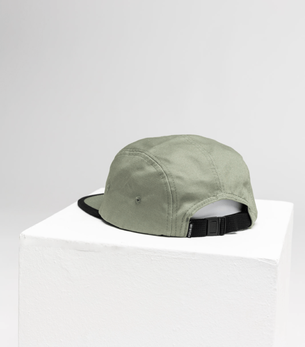 back of focus green 5 panel cap on white cube