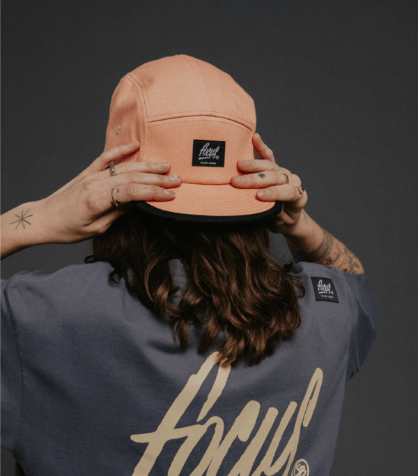 5 panel pink cap on female model holding her head