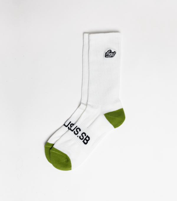 white sport socks with green heel and toes and logo embroidered on the side