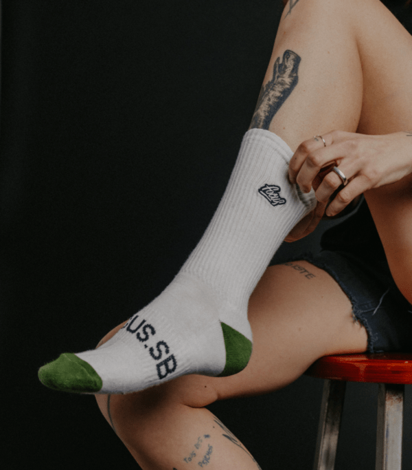 white and green sock on female model sitting on stool